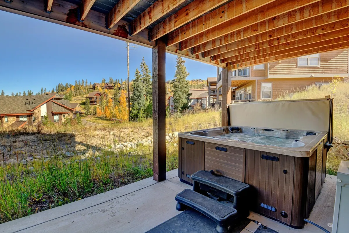 This image showcases a private hot tub set outdoors, framed by sturdy wooden beams and surrounded by natural scenery. The inviting water is ready for a soak, and the area conveys both privacy and tranquility, ideal for relaxing under the stars or after an adventure-filled day.