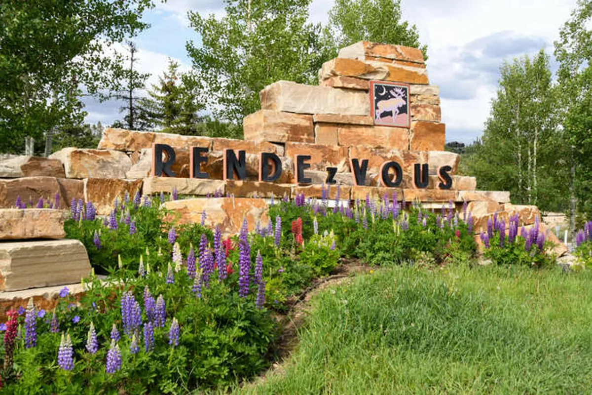 This exterior image features beautifully maintained flower beds, eye-catching signage, and a charming stone structure. The surroundings look pristine and inviting, echoing the property’s commitment to a clean and welcoming environment, without evidence of pet use or animal presence.